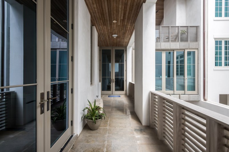 E.-F.-San-Juan-Alys-Beach-Florida-Custom-Wood-Railings custom wood facade, custom railings, custom ceiling, courtyard design, alys beach florida, windows and doors, hurricane-rated millwork, satina hardwood design, khoury vogt architects, e f san juan